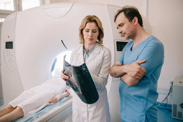 Medici premurosi guardando la diagnosi a raggi X durante la diagnostica dei pazienti su scanner ct — Foto stock