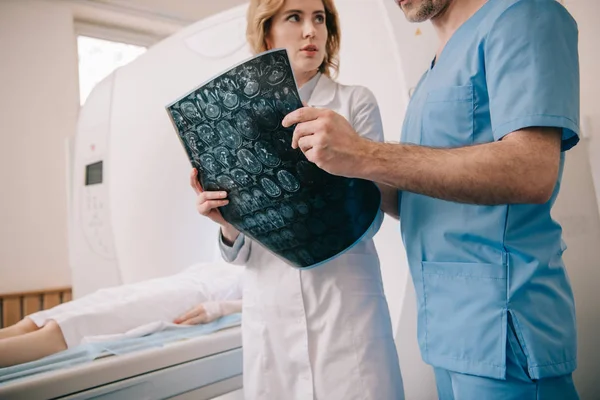 Vue recadrée du médecin examinant le diagnostic de tomographie avec radiologue — Photo de stock