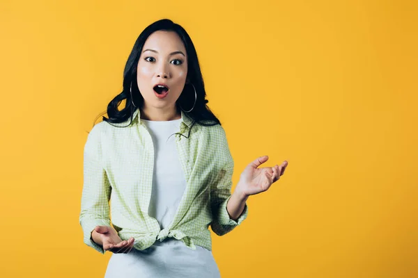 Emotivo asiatico giovane donna isolato su giallo — Foto stock