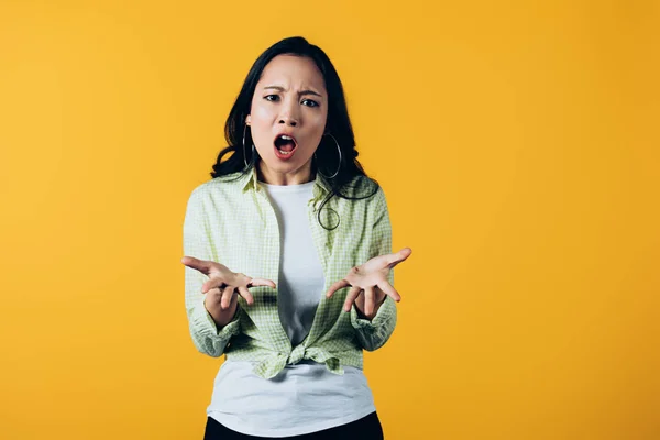 Aggressive asian woman yelling isolated on yellow — Stock Photo