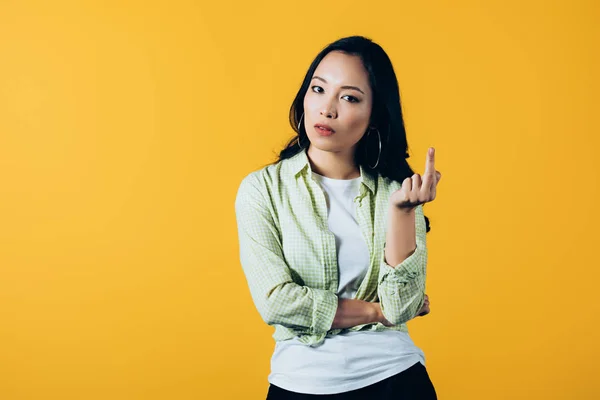 Attractive asian girl pointing up isolated on yellow — Stock Photo