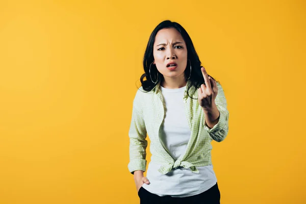 Сердитая азиатская девушка, указывающая на изолированный желтый — стоковое фото