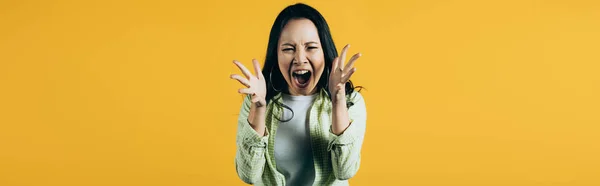 Angry asian woman gesturing and yelling isolated on yellow — Stock Photo