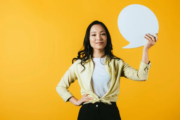 Casual asiático mulher segurando discurso bolha, isolado no amarelo — Fotografia de Stock