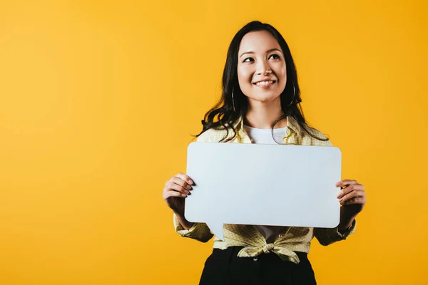 Smiling asian woman holding speech bubble, isolated on yellow — Stock Photo