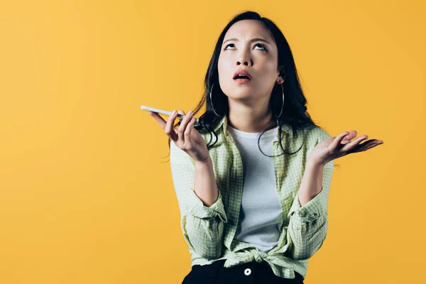 Attractive asian girl smartphone isolated on yellow — Stock Photo