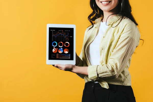 Vista recortada de chica mostrando tableta digital con infografía, aislada en amarillo - foto de stock