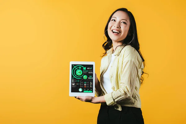 Sorrindo asiático menina mostrando digital tablet com infográfico, isolado no amarelo — Fotografia de Stock
