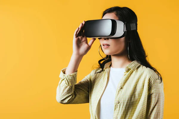 Дівчина використовує гарнітуру віртуальної реальності, ізольована на жовтому — Stock Photo