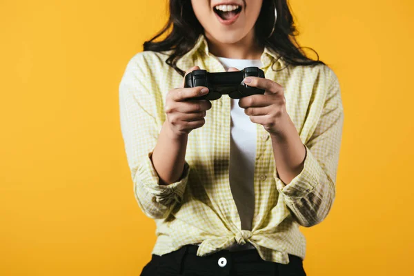 KYIV, UKRAINE - 16 AVRIL 2019 : excité asiatique fille jouer jeu vidéo avec joystick, isolé sur jaune — Photo de stock