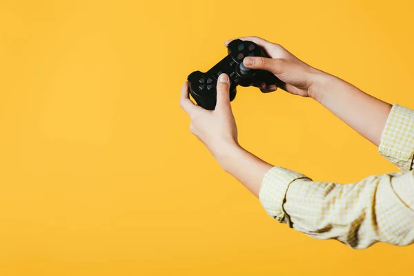 KYIV, UKRAINE - APRIL 16, 2019: cropped view of woman playing video game with joystick, isolated on yellow — Stock Photo