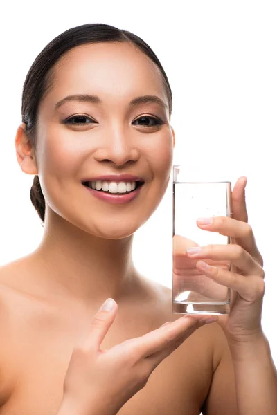 Привлекательная улыбающаяся женщина со стаканом воды, изолированная на белом — стоковое фото