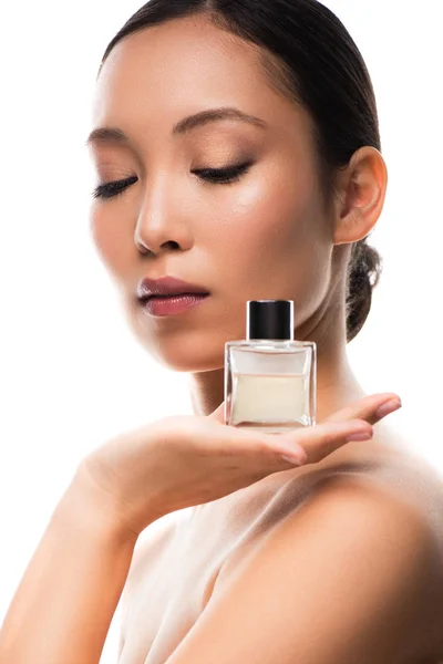 Tender asian girl with closed eyes holding perfume, isolated on white — Stock Photo