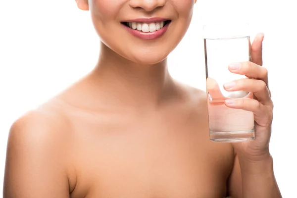Vue recadrée d'une femme souriante avec verre d'eau, isolée sur fond blanc — Photo de stock