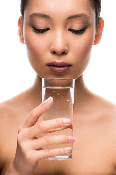 Привлекательная азиатка держит стакан воды, изолированный на белом — стоковое фото