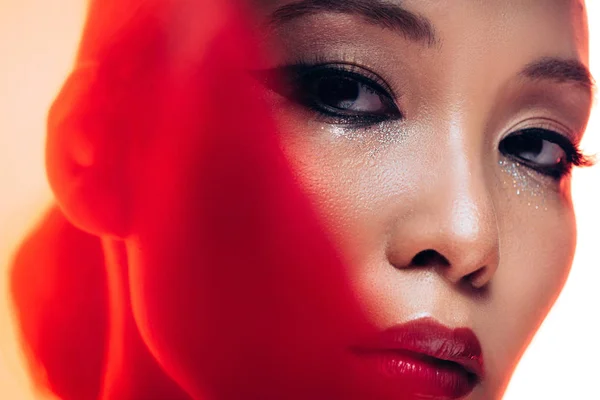 Perfecto asiático mujer con maquillaje en rojo luz - foto de stock