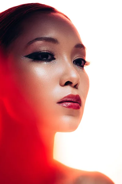 Hermosa mujer asiática en rojo luz, aislado en blanco - foto de stock