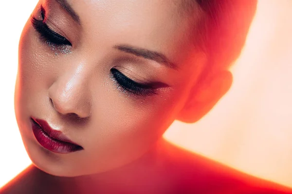 Beautiful asian woman in red light, toned picture — Stock Photo