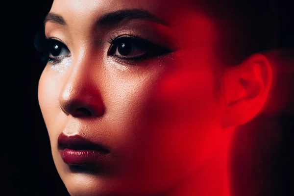Close up of attractive asian girl with makeup in red light — Stock Photo