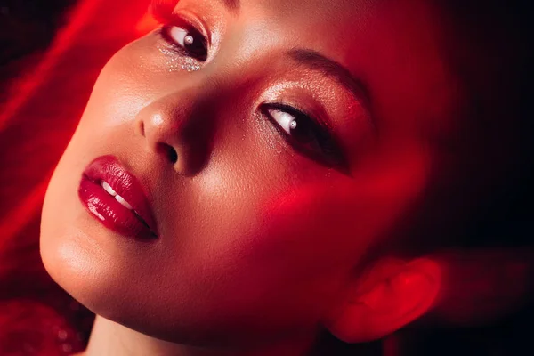 Vicino di attraente sensuale asiatico ragazza con il trucco in rosso luce — Foto stock