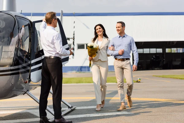 Marido feliz e esposa na data romântica perto de helicóptero e piloto — Fotografia de Stock