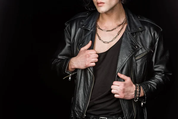 Vista ritagliata di giovane uomo toccare giacca di pelle isolata su nero — Foto stock