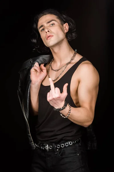 Handsome man showing middle finger while holding leather jacket isolated on black — Stock Photo