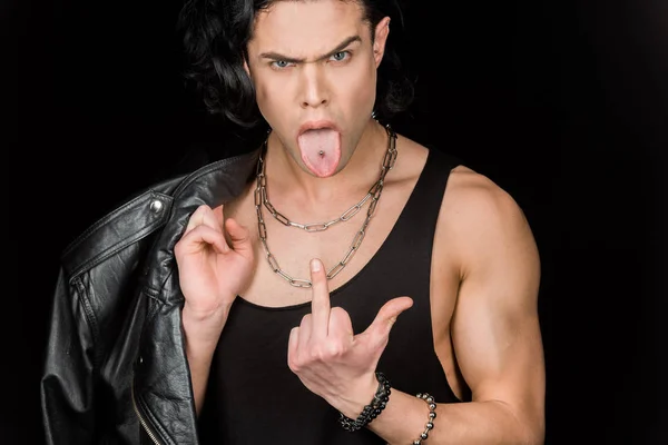 Man showing middle finger and tongue while holding leather jacket isolated on black — Stock Photo