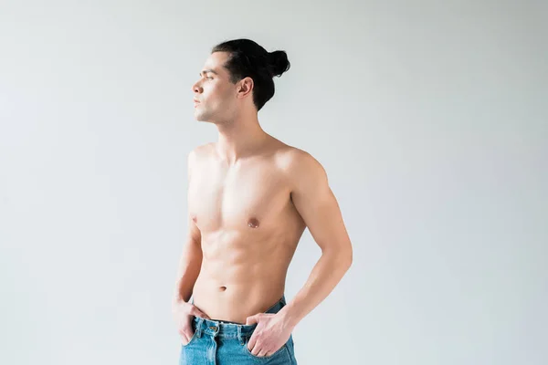Handsome shirtless man standing with hands in pockets on white — Stock Photo