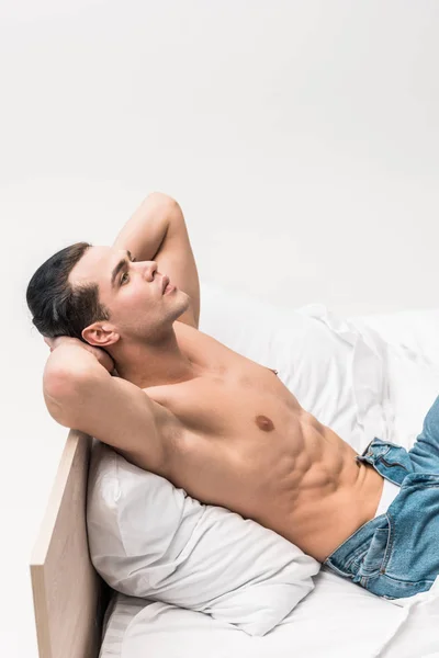 Senza maglietta e bello uomo rilassante sul letto a casa — Foto stock