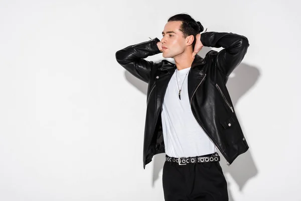 Stylish young man in leather jacket standing on white — Stock Photo