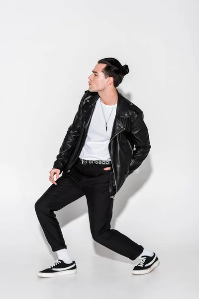 Handsome man in black leather jacket posing on white — Stock Photo