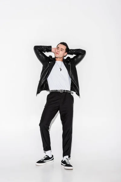 Handsome man in black leather jacket posing while standing on white — Stock Photo