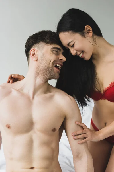 Amour interracial couple rire et regarder l'autre dans chambre — Photo de stock