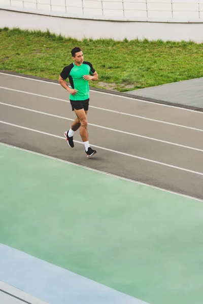 Visão de comprimento total de esportes de corrida mista correndo no estádio — Fotografia de Stock