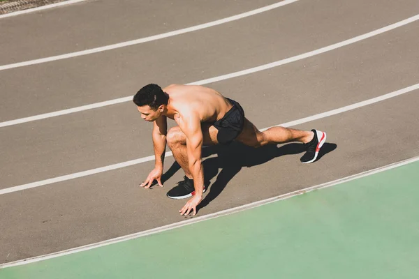 Visão aérea do desportista misto que se prepara para correr no estádio — Fotografia de Stock