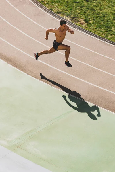 Overhead view of mixed race sportsman running at stadium — Stock Photo