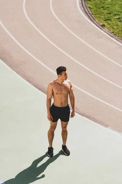 Full length view of mixed race sportsman standing at stadium — Stock Photo