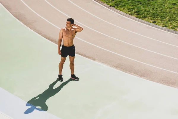 Full length view of mixed race sportsman standing at stadium — Stock Photo