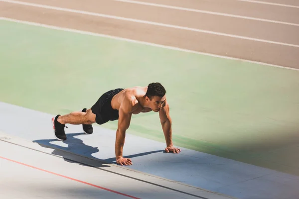 Deportista de carrera mixta de pie en tablón en el estadio — Stock Photo