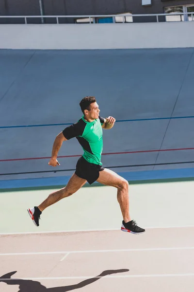 Vista completa del deportista de carrera mixta corriendo en el estadio - foto de stock