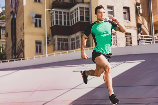 Full length view of mixed race sportsman running at stadium — Stock Photo