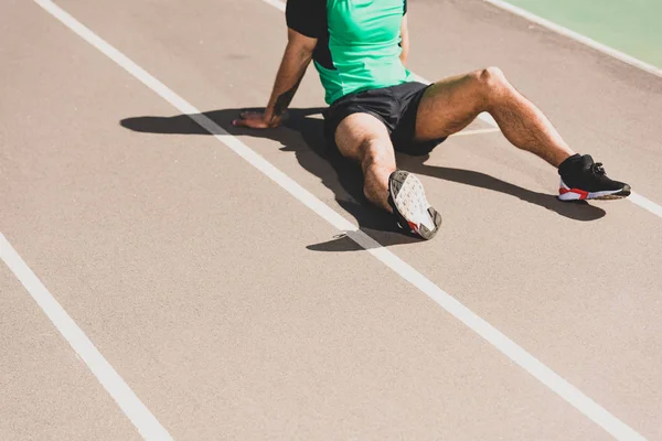 Vista parcial del deportista de carrera mixta sentado en el estadio — Stock Photo