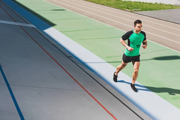 Full length view of mixed race sportsman running at stadium — Stock Photo