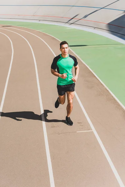 Vista integrale dello sportivo di razza mista che corre allo stadio — Foto stock