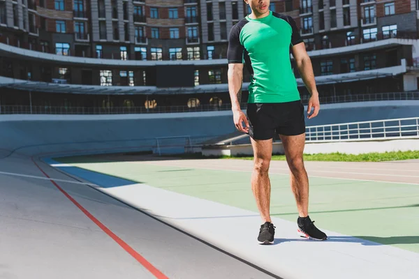 Cropped view of sportsman in sportswear standing at stadium — Stock Photo