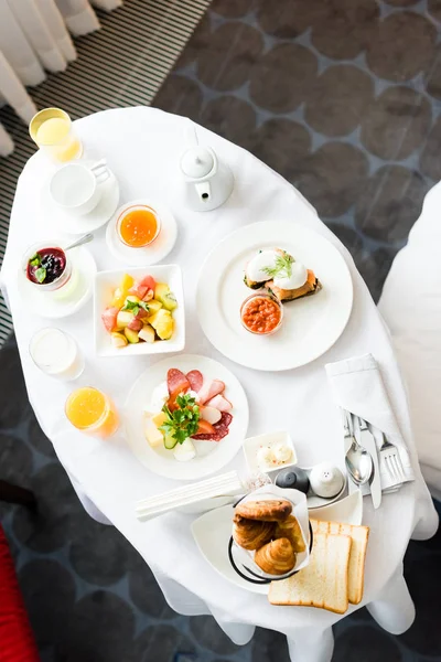 Vista superior del delicioso desayuno cerca de la taza y vasos con jugo de naranja en la mesa — Stock Photo