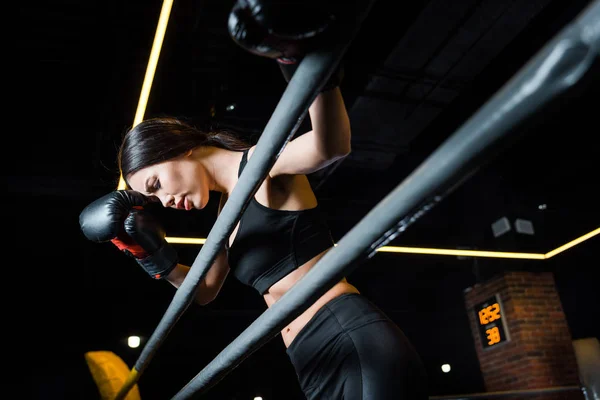 Вид на красивую женщину в боксёрских перчатках, стоящую в спортзале — стоковое фото