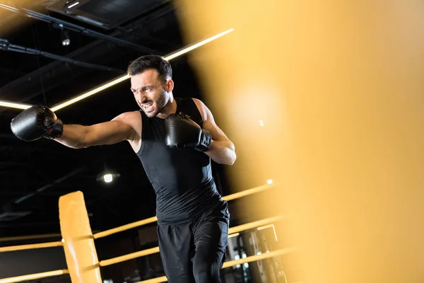 Selective focus of athletic bearded man boxing in sports center — Stock Photo