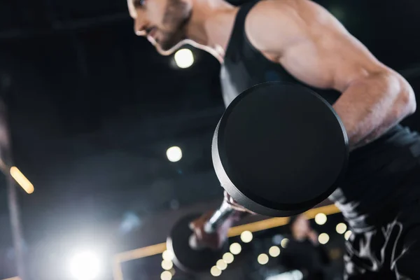 Enfoque selectivo del hombre fuerte ejercicio con pesadas pesas en el gimnasio - foto de stock